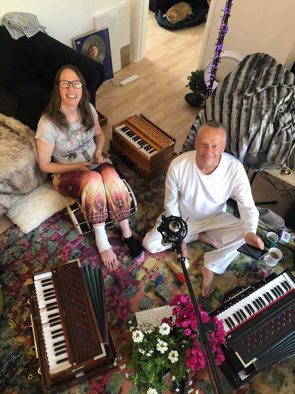 Trio playing harmoniums and tabla at a kirtan session
