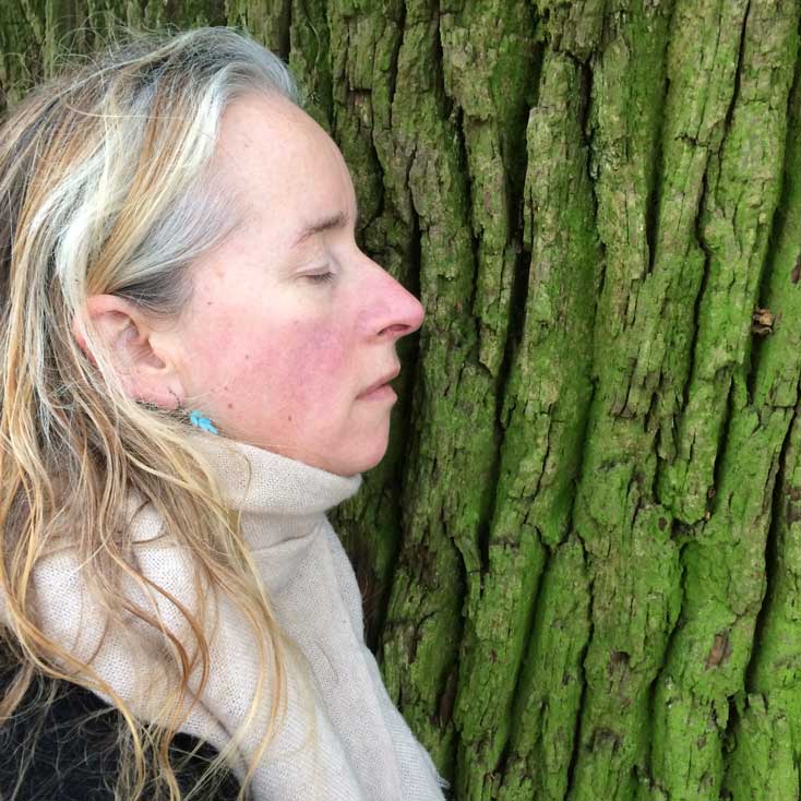 Alys Hennessy in quiet contemplation, resting against a tree